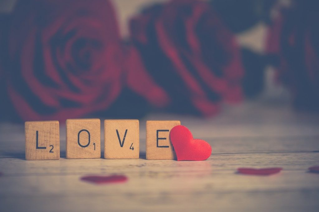 Scrabble tiles spelling love and red roses